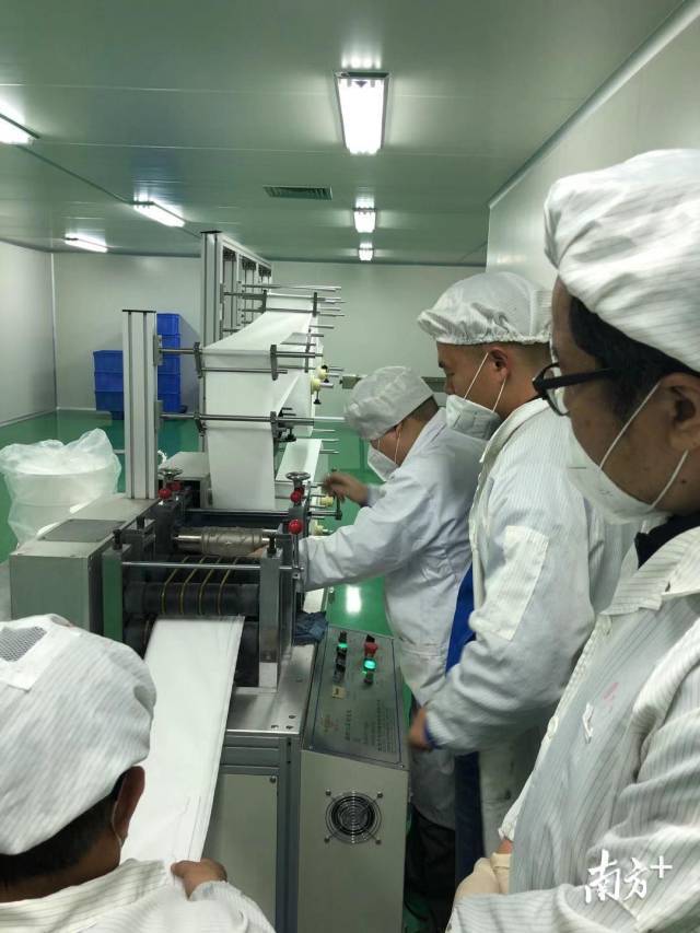 九明制药公司员工查看新增口罩生产线。