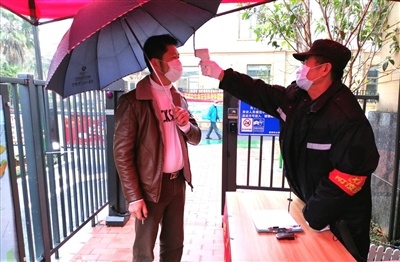 康城水郡小区保安对外出归来的业主进行体温测量。河源日报记者 王永红 摄 康城水郡小区保安对外出归来的业主进行体温测量。河源日报记者 王永红 摄