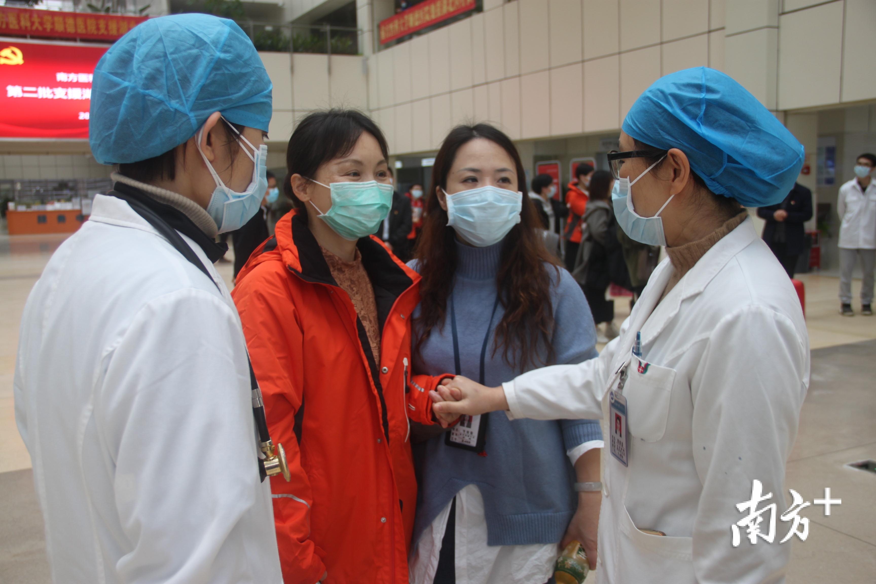中国好人李国华（左二）担任此次医疗队领队，在出征前同事为她击拳打气。