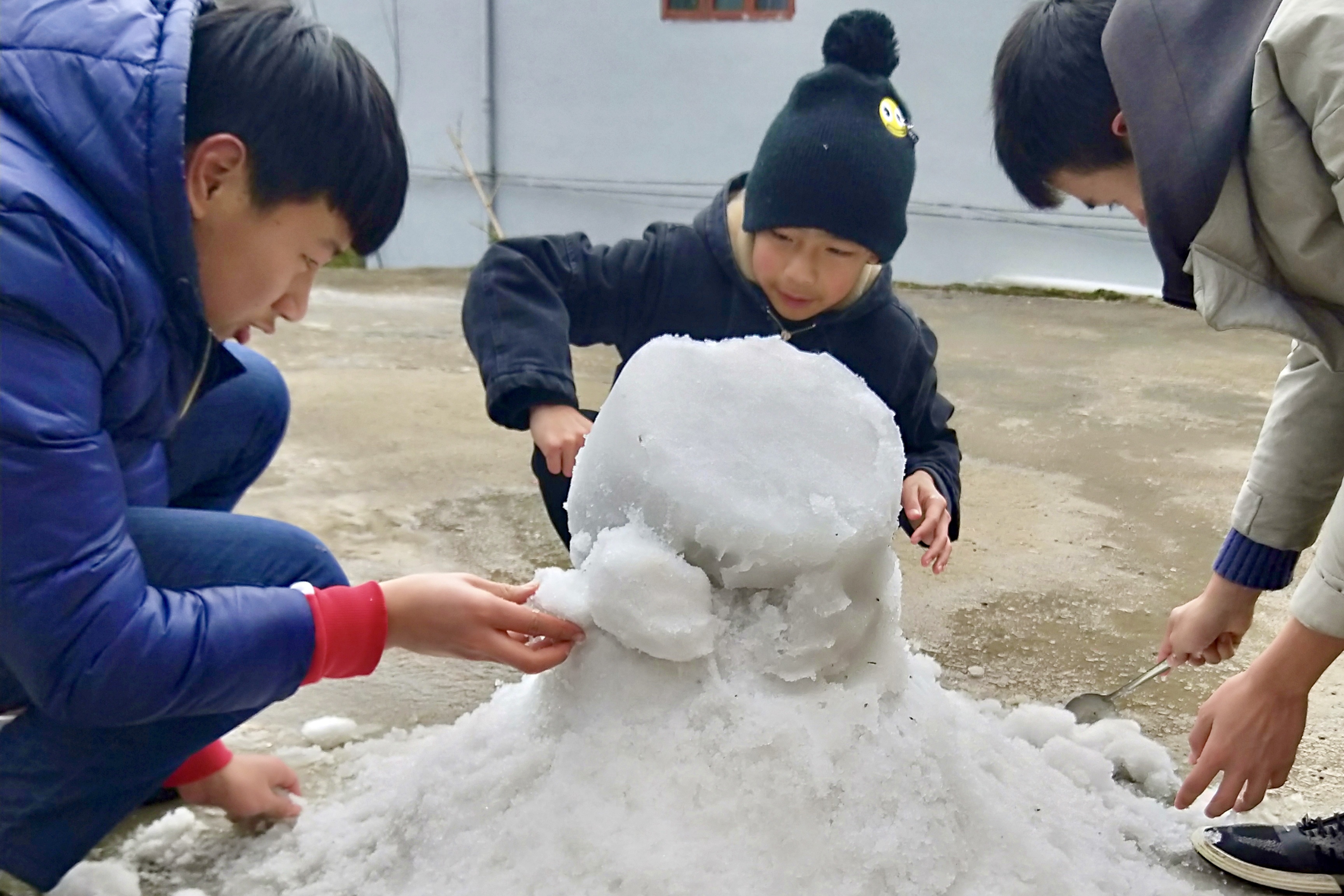 16日上午,阳光照耀下的积雪开始融化,村民小孩们笑着到处收集积雪,赶