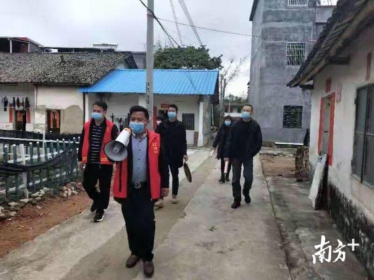 龙门县人大代表黄子能用大喇叭在龙田镇西埔村里宣传。