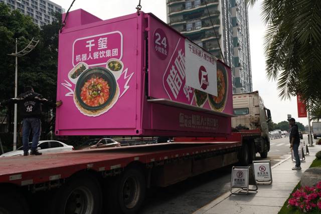2月13日，集装箱式煲仔饭机器人被吊装上货车，出发前往武汉。受访者供图