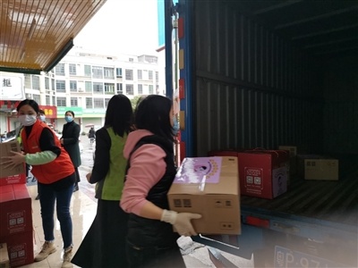 志愿者将一箱箱打包好的新鲜食材装车。