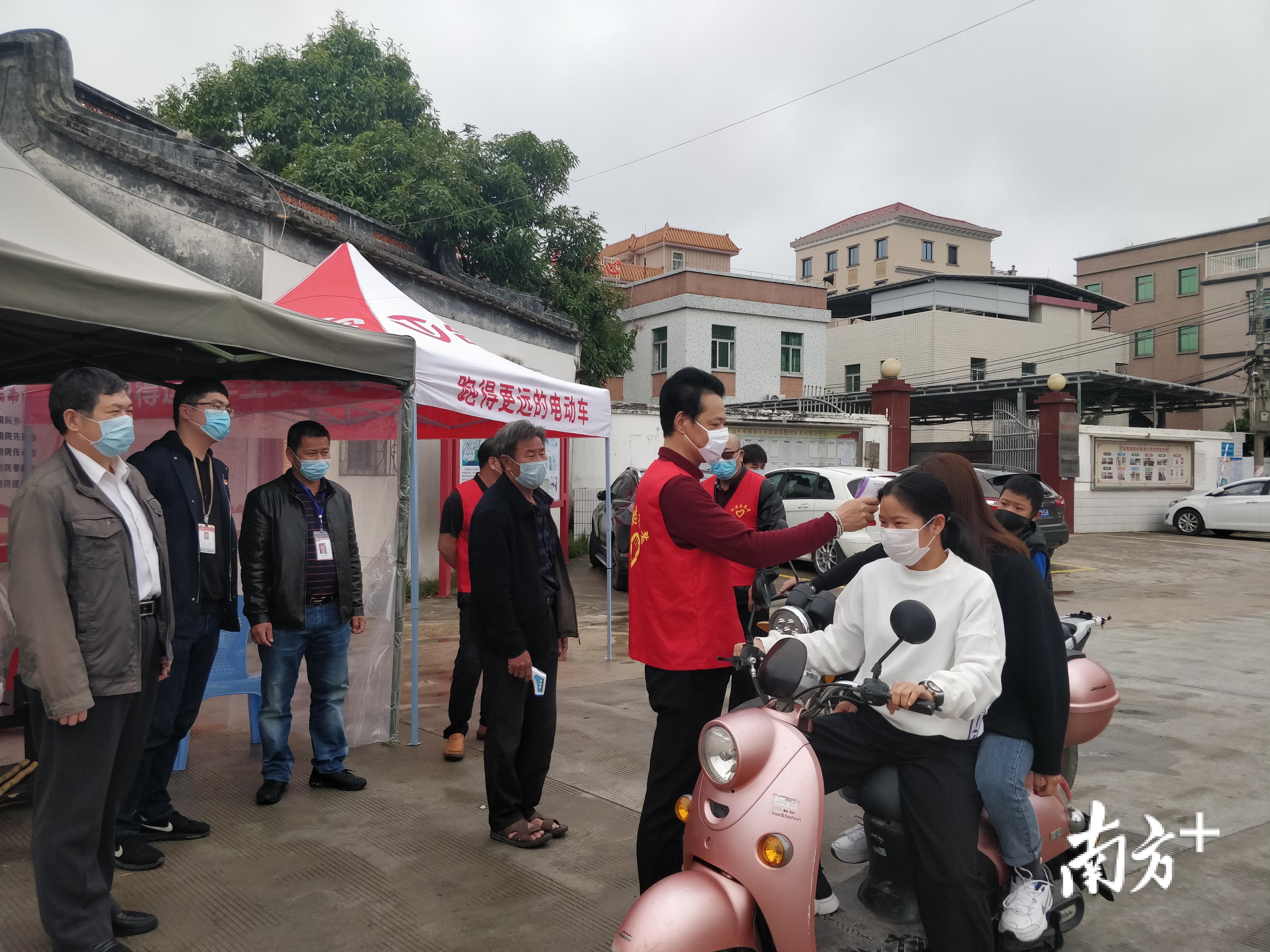 南陇村志愿者主动参与到交通卡口检测点，为过往行人测体温。
