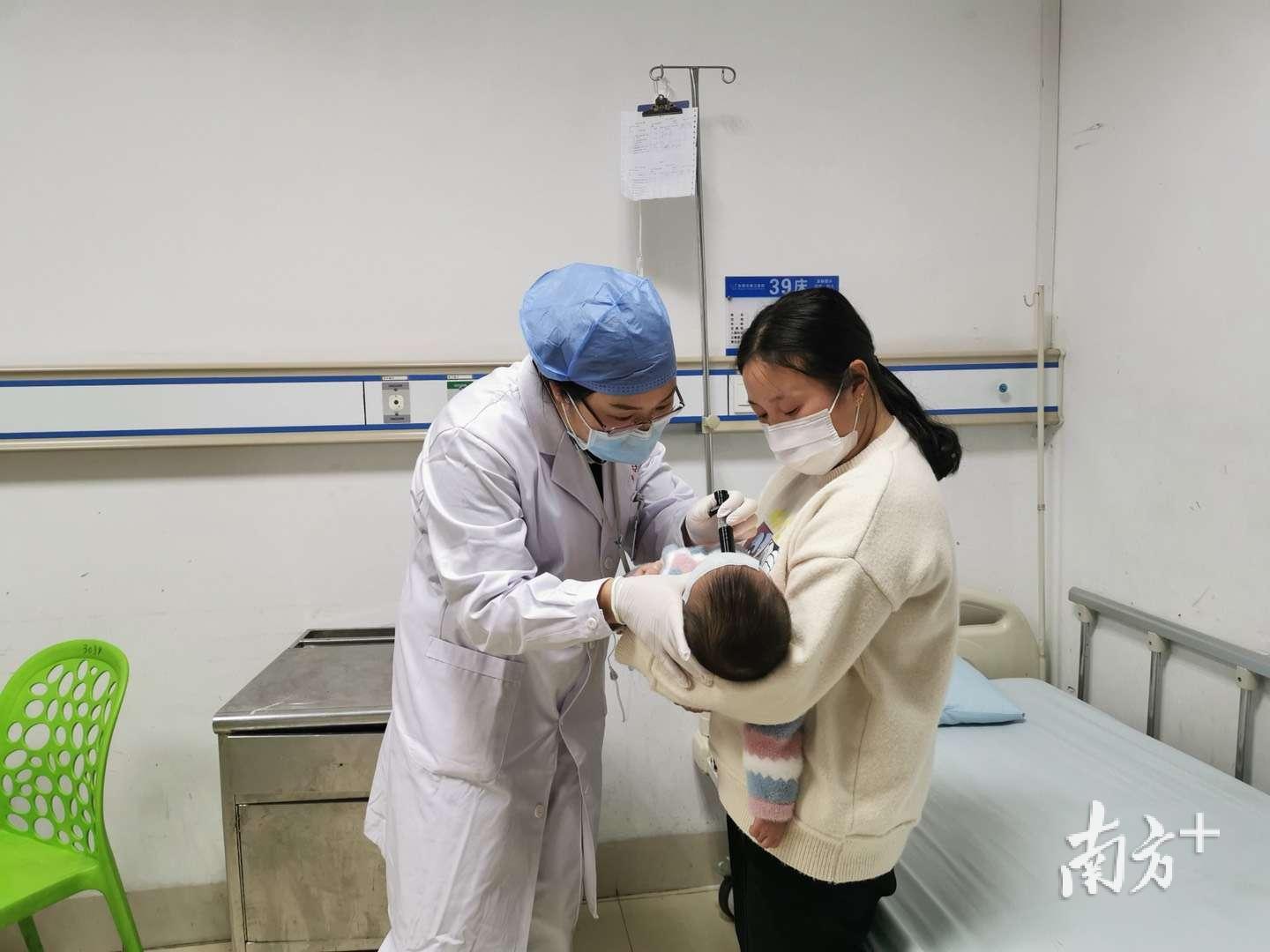 儿科主治医师刘浪平（左）在为患儿检查。