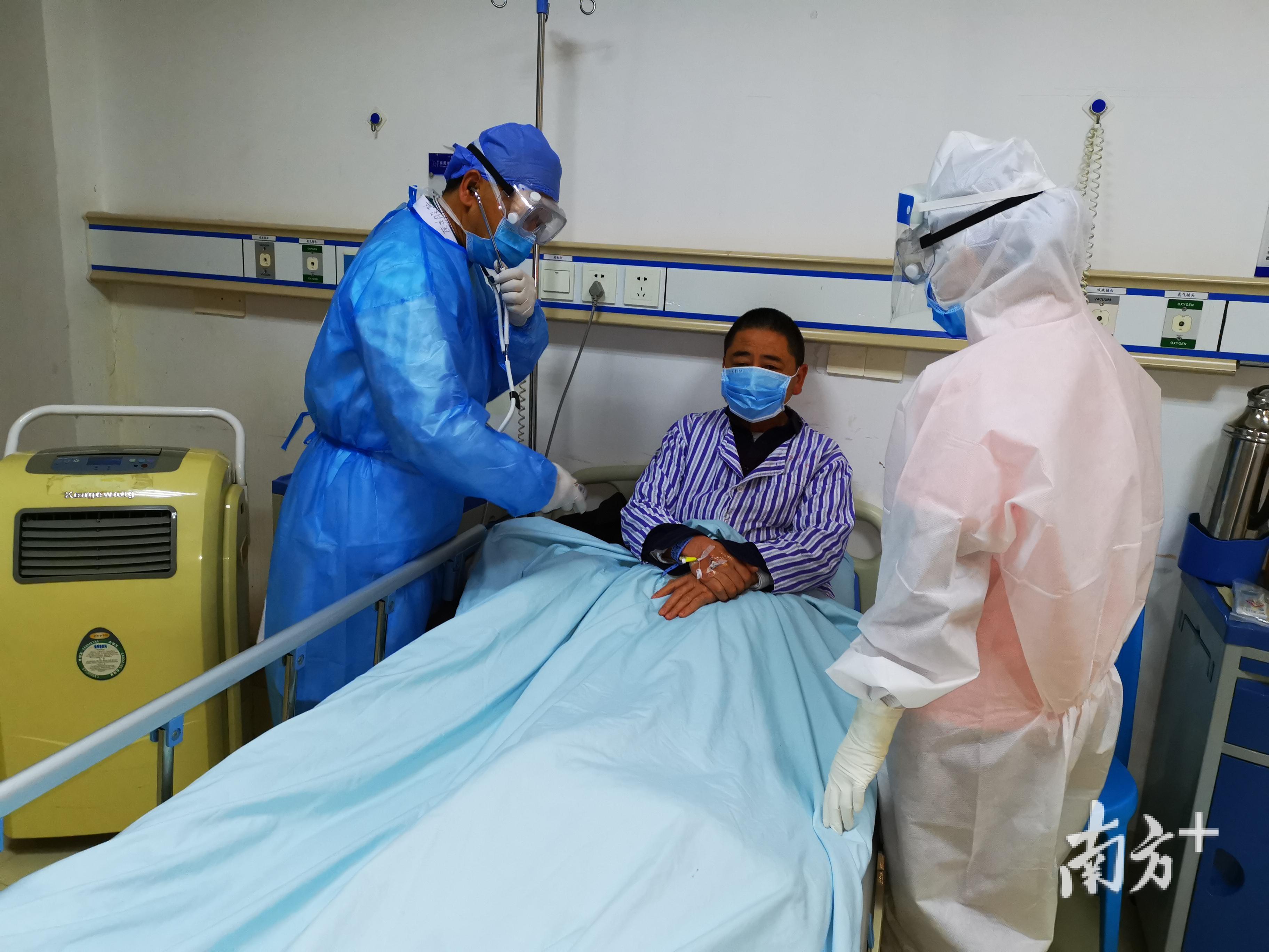 主任医师骆训武（左一）在发热一病区查房。