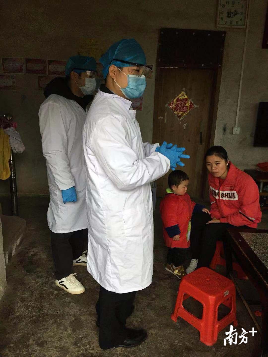 李永富逐户为村民测量体温。