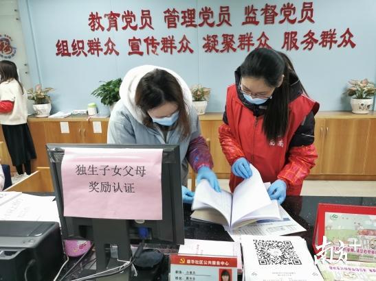 三水西南街道康华社区党委书记莫美华（右一）正在和工作人员一起查看表格。黄逸豪摄