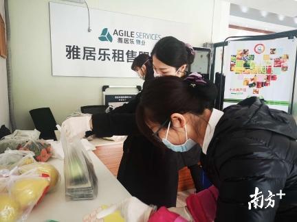 雅居乐物业三水区域商业经营主管何炜棋（右一）正为业主配送蔬菜、水果。李周秦摄