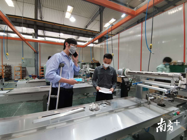 四川客户王先生正在了解口罩包装机的技术指标。熊程摄