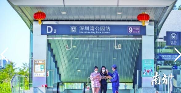地铁深圳湾公园站，工作人员为游客测量体温。