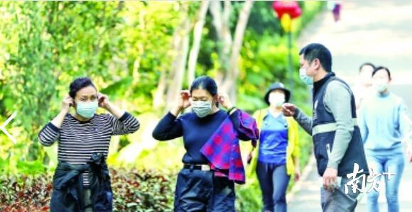 莲花山公园内，工作人员正在劝导市民戴好口罩。