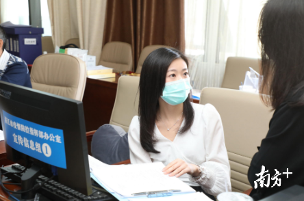 宣传信息组成员	、湛江市卫健局宣传科副科长陈晨在与同事商讨工作	。 张锋锋  摄