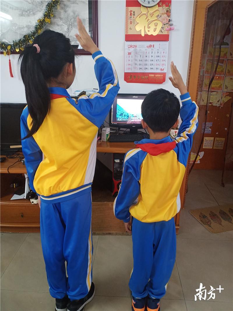 启明小学——姐姐带着弟弟升国旗。