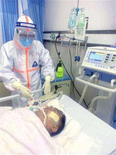 黄航辉穿着厚厚的防护服细心护理ICU里的患者。