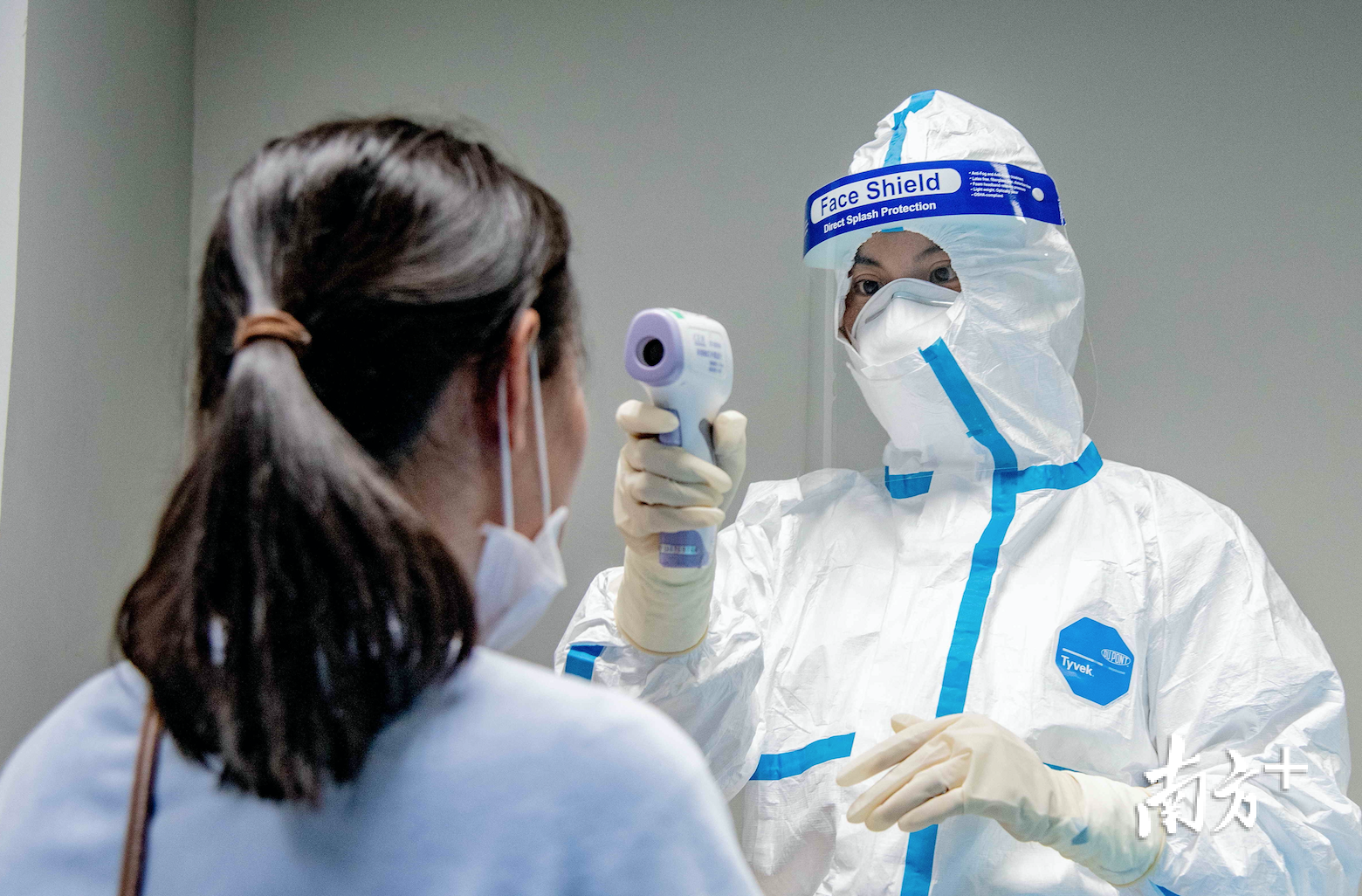 王丽萍为入境旅客测量体温。