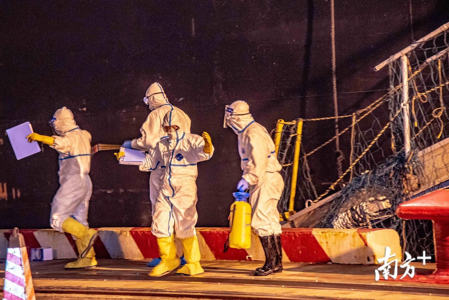 蔡雪妍（右二）完成处置后在解除防护装备前进行消毒。