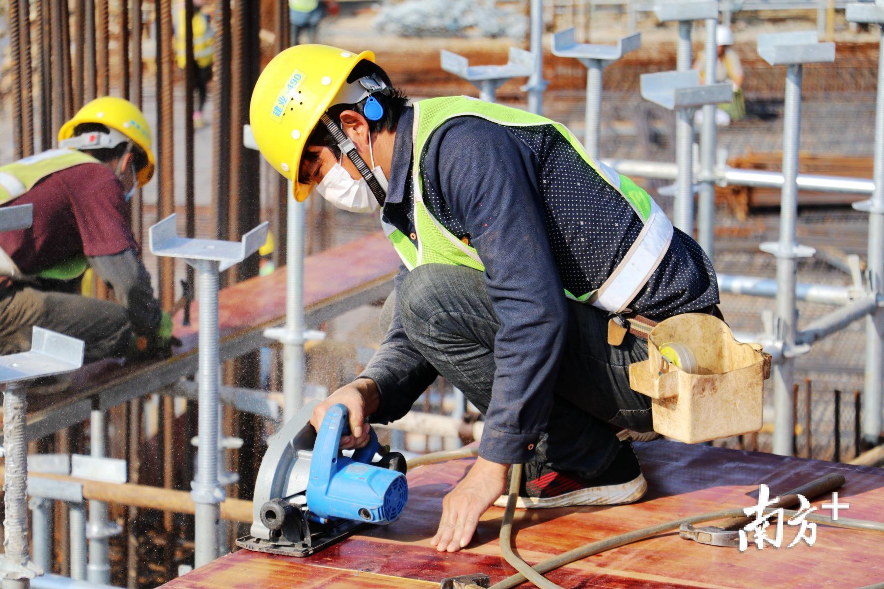 工人佩戴口罩进行模板切割作业。 工人佩戴口罩进行模板切割作业。