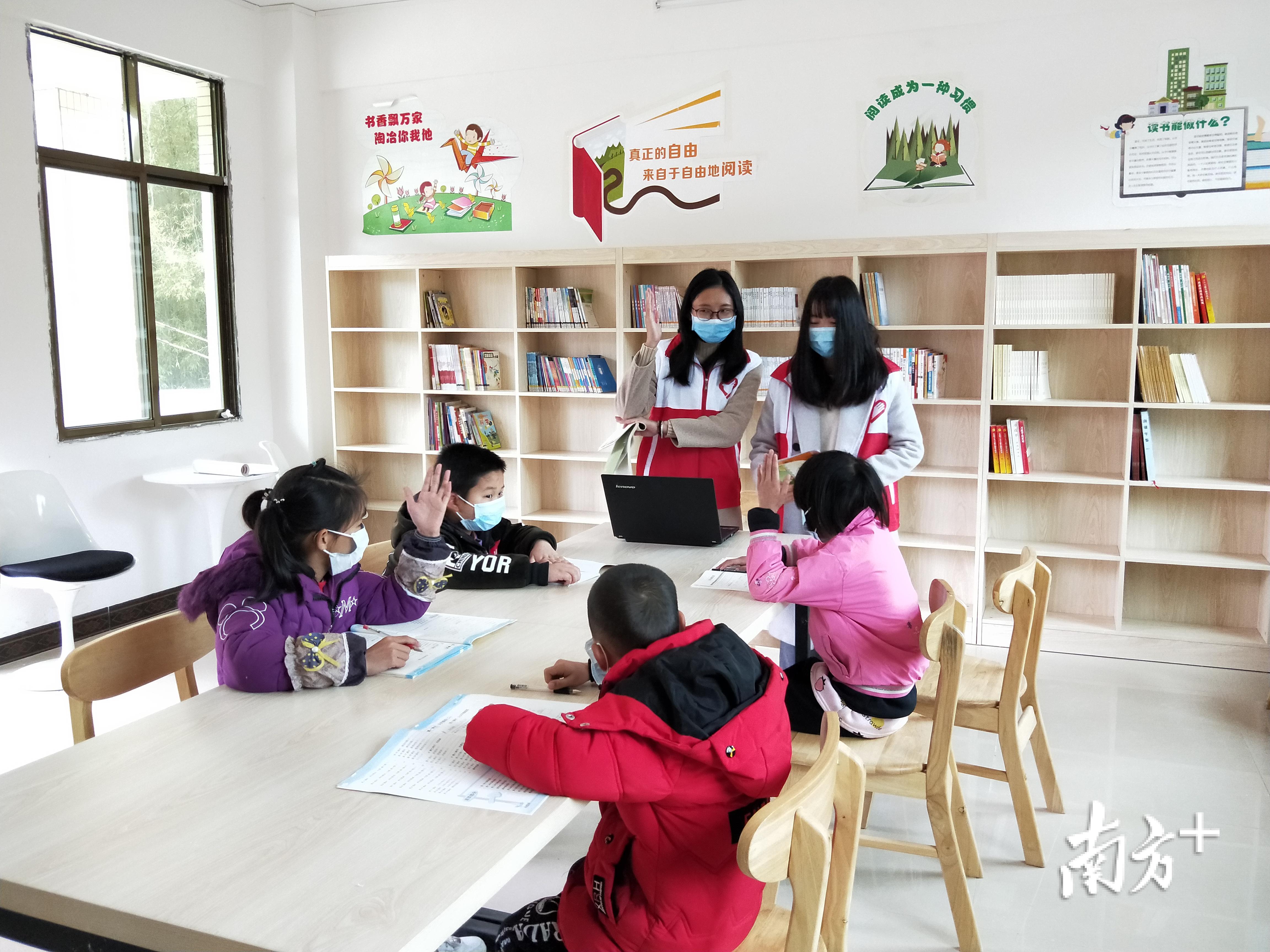 韶关南雄市南亩镇中寺村驻村干部黄莉和赵园园在“特殊课堂”为孩子辅导功课。通讯员供图