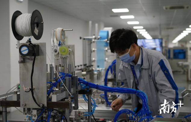 德富莱工人正在调试口罩机。摄影/记者李荣华 德富莱工人正在调试口罩机。摄影/记者李荣华