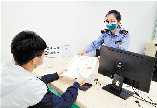 邝先生领到开平市发出的首张“智能湾区通”营业执照。