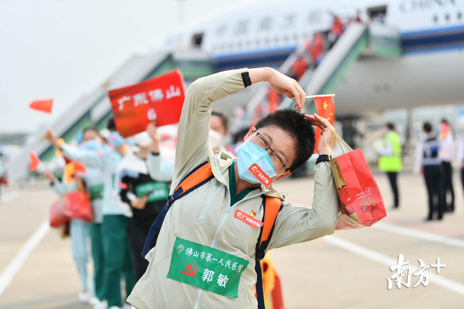 3月23日，抵达广州白云机场的佛山医疗队队员向镜头做出“比心”的动作。戴嘉信 摄