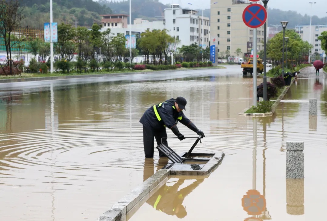 市政工人疏通下水道，尽快排除积水。