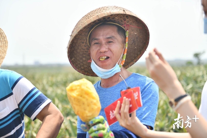 黄明夫现场给菠萝削皮让大家品尝，清香多汁的菠萝让大家吃得很开心。