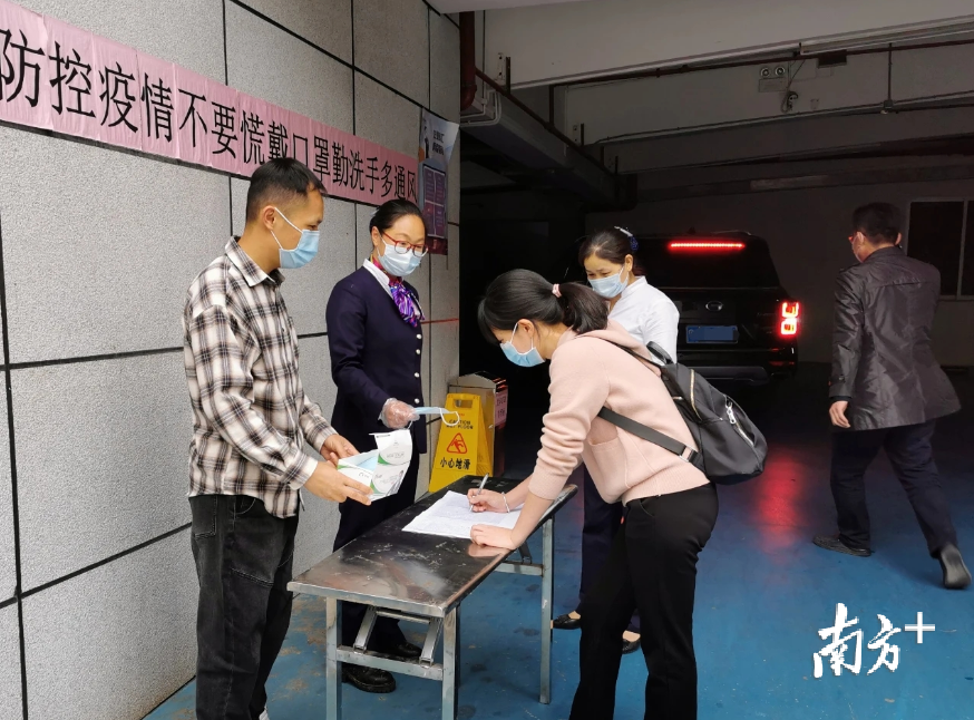 近日，佛冈县法院“后勤管家”郭志新（左一）正在给职工们登记体温情况。程浩 摄