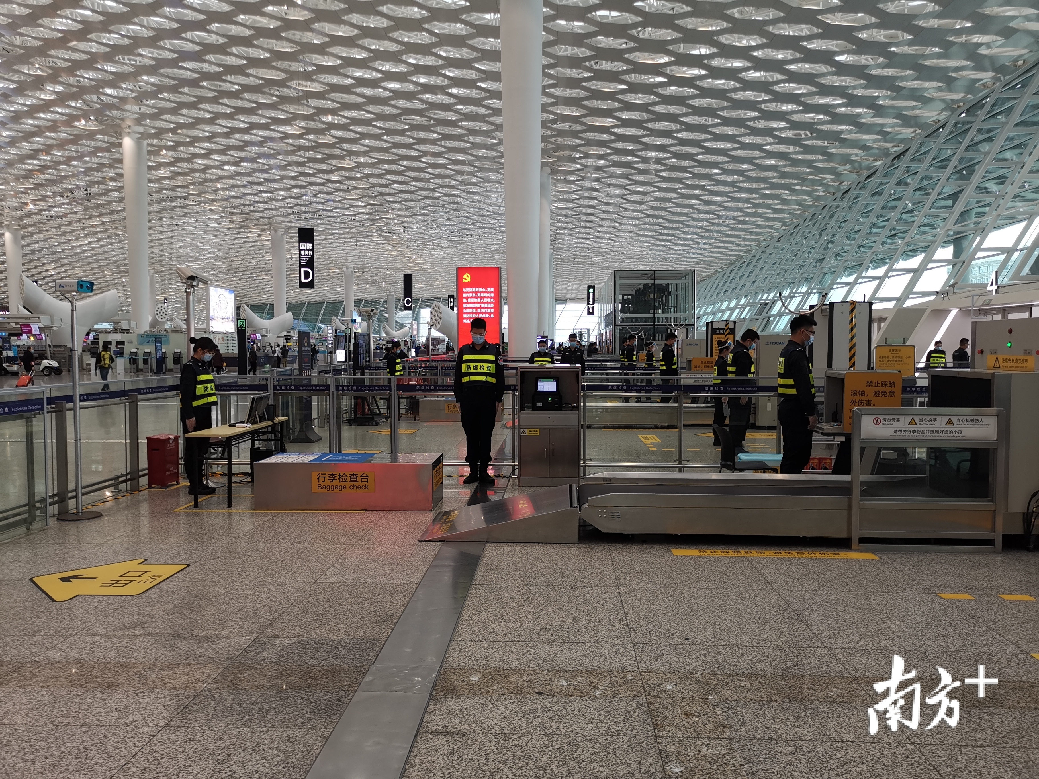深圳机场安检站安检员和出行旅客们在机场出发大厅内外默哀
