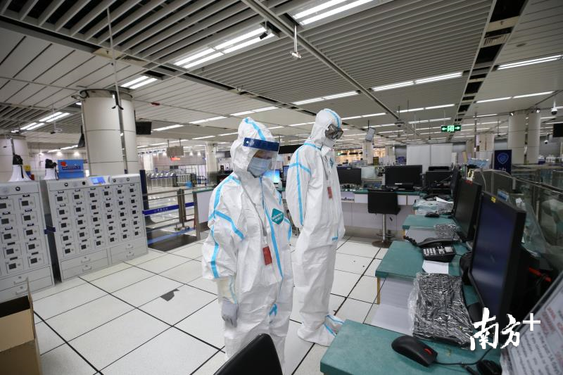 深圳湾口岸，身着防护服的边检民警正在默哀。