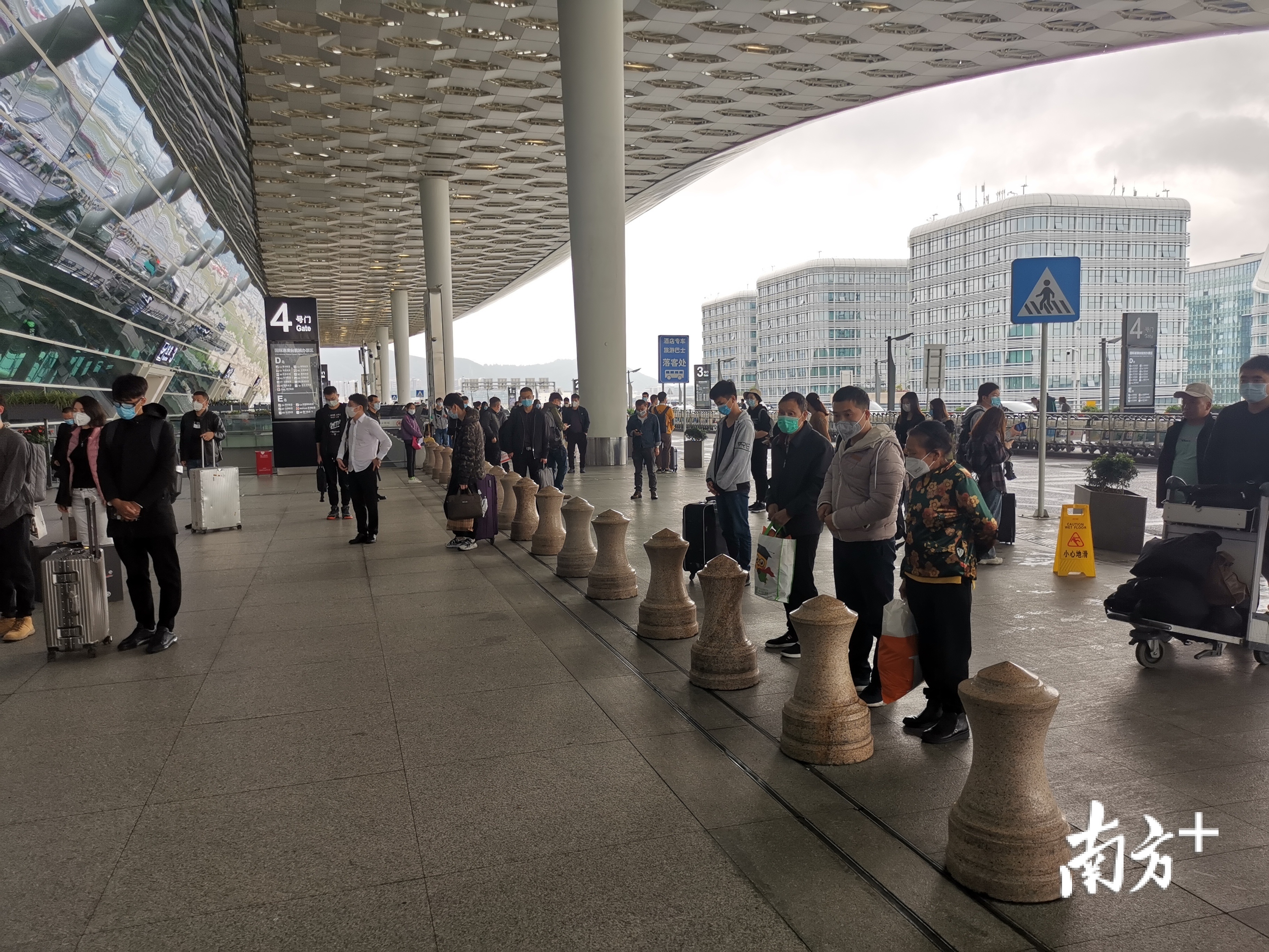 深圳机场安检站安检员和出行旅客们在机场出发大厅内外默哀