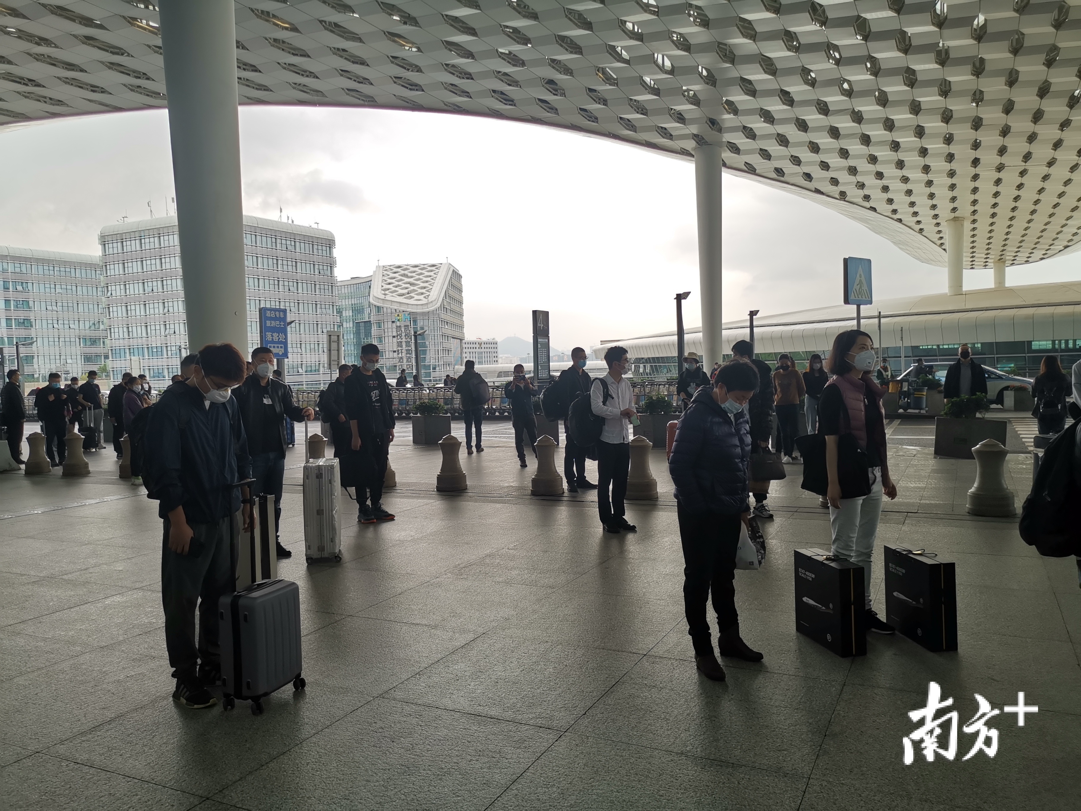 深圳机场安检站安检员和出行旅客们在机场出发大厅内外默哀