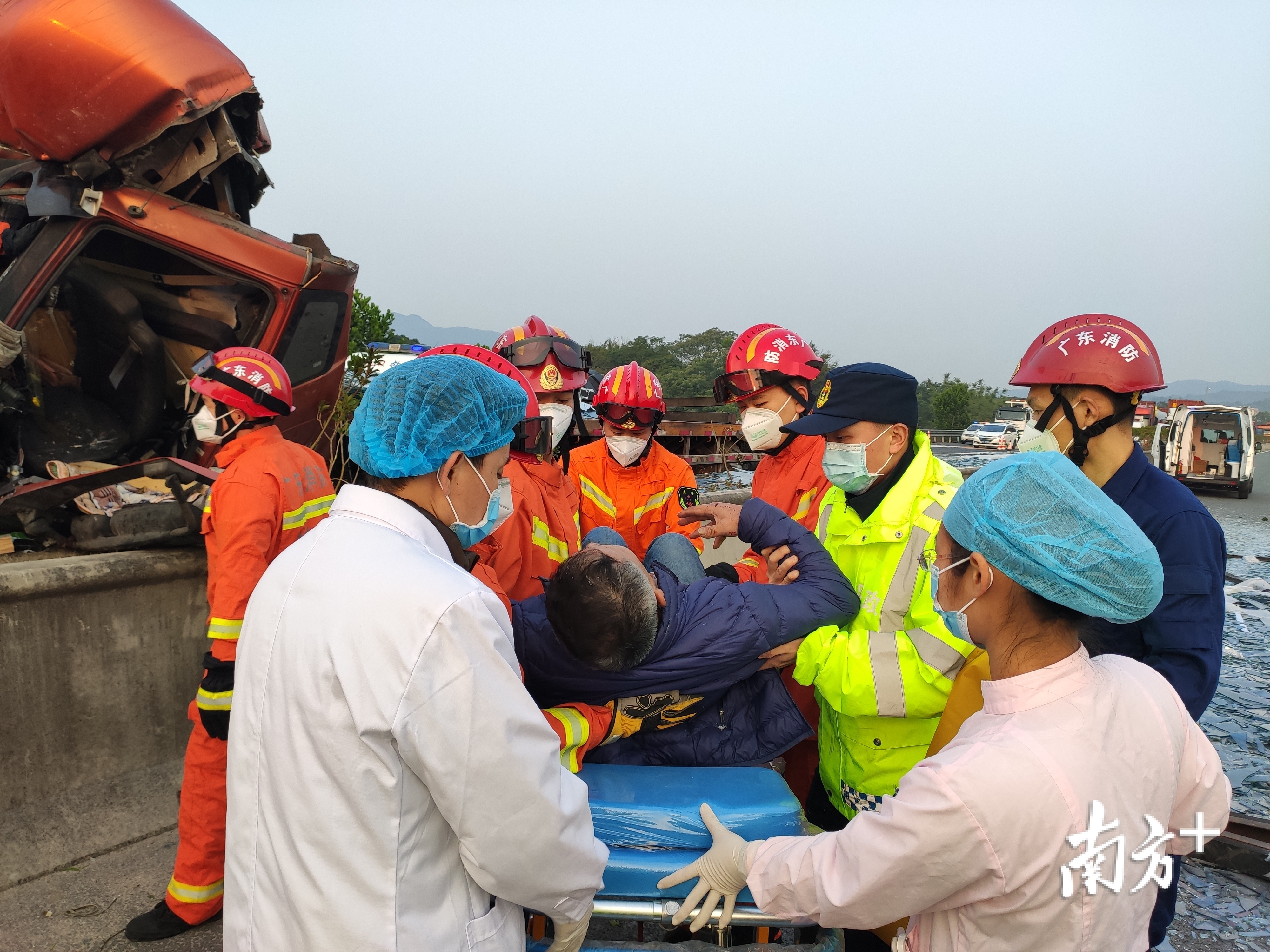 受伤司机被抬上担架送医治疗。