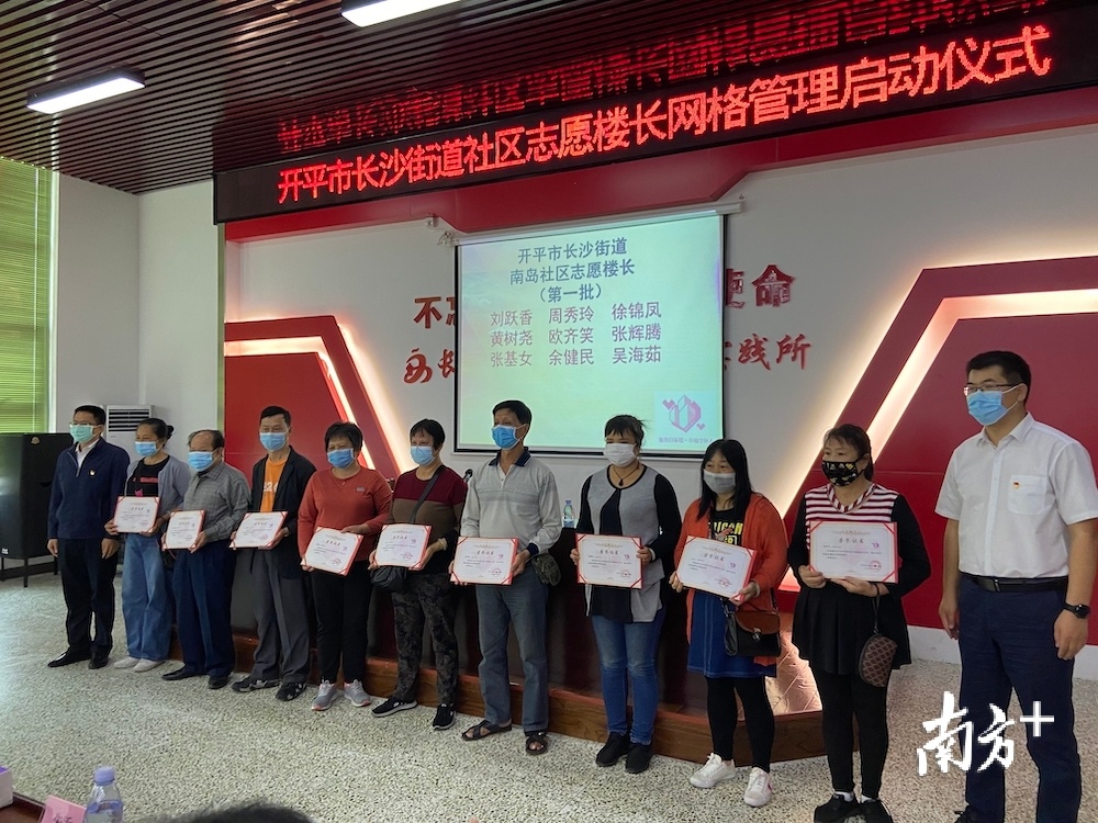 为第一批志愿楼长颁发证书。郑琦摄