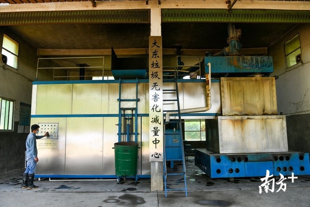 在大东镇坪山村的垃圾无害化减量中心，工人将垃圾送进处理机送料口后，对垃圾进行高温分解，实现垃圾就近处理，减少了二次污染。（南方日报记者 何森垚 摄）