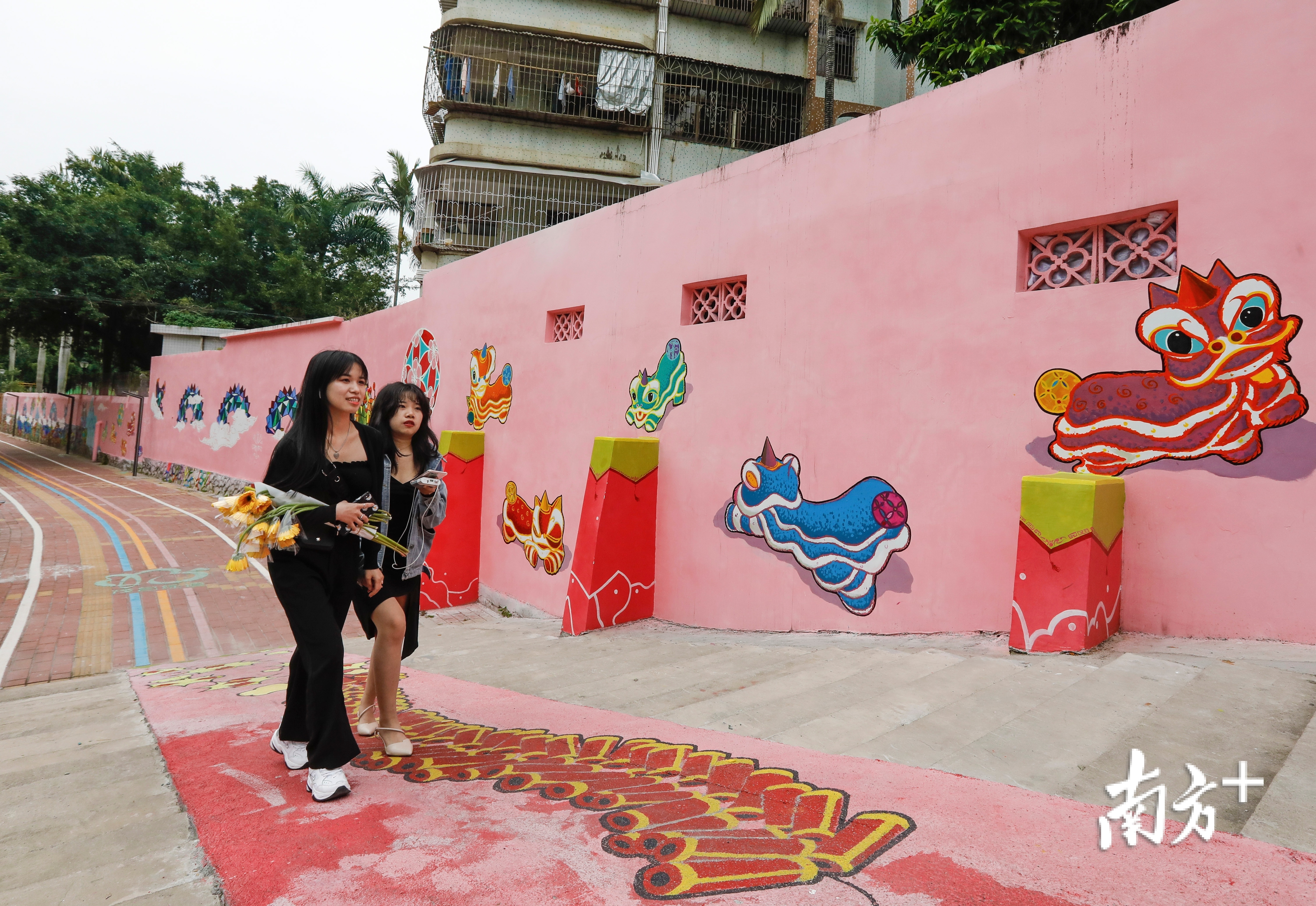 好心绿道经过的隔坑小区，融合中国传统文化人龙舞和茂名山海自然元素创作而成的《人龙舞 海图腾》彩绘长廊。