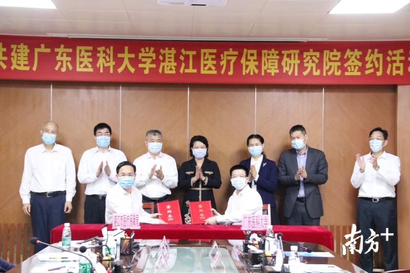 广东医科大学副校长曾志嵘（前排右）及湛江市医疗保障局局长方如江（前排左）进行共建研究院签约。