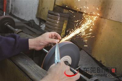 ▲汤锐洪老人在给顾客磨剪刀