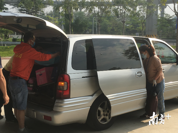 工作人员将学生行李装摆渡车，运到校内。