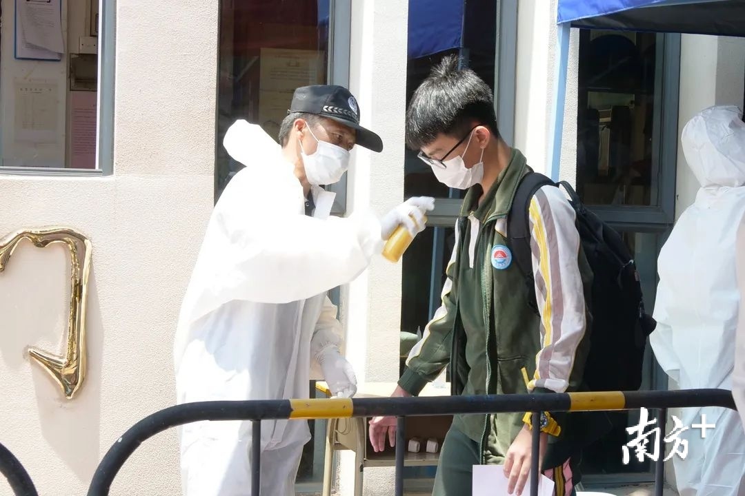 万江中学学生入校前进行消毒。