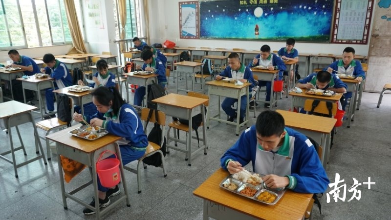 江门十一中学生中午在教室内就餐。