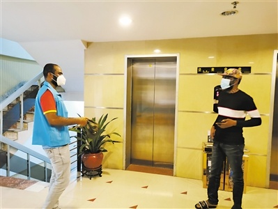 志愿者“发财”（左）与酒店旅客交谈。