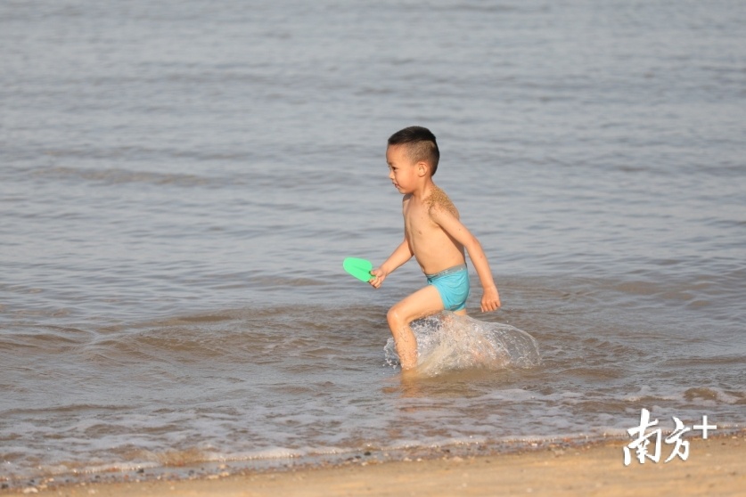 小朋友在海边追着海浪