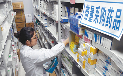 江西南昌大学第二附属医院药房内，医师正在带量采购药品的药架前为患者取药。时雨 摄