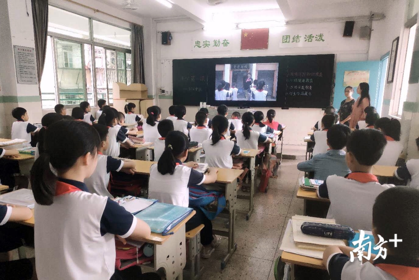 城南小学的学生们在教室里观看升旗仪式并聆听国旗下的讲话。 城南小学的学生们在教室里观看升旗仪式并聆听国旗下的讲话。