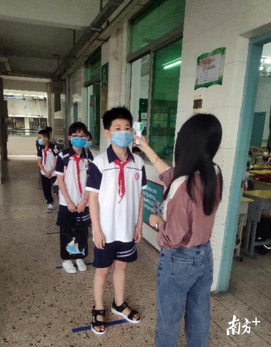 城南小学学生经过校门口、教室门口两次体温检测后,才能进入教室。