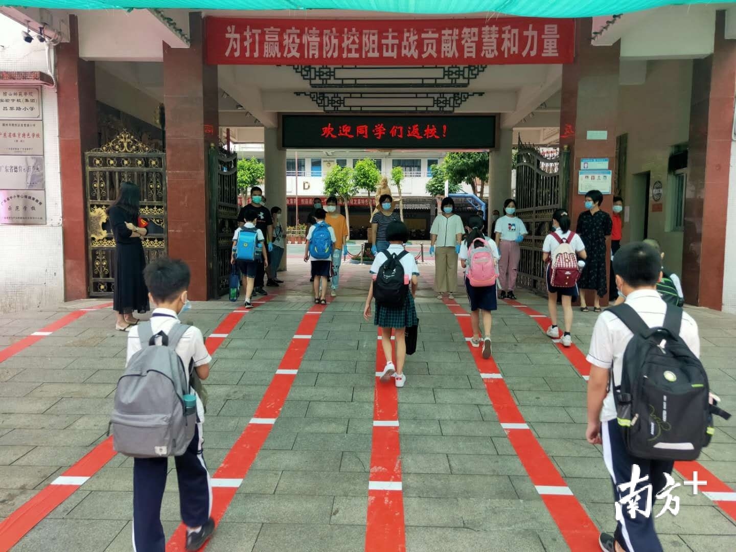 5月11日,湘桥区昌黎路小学的学生有序接受体温检测进入学校.