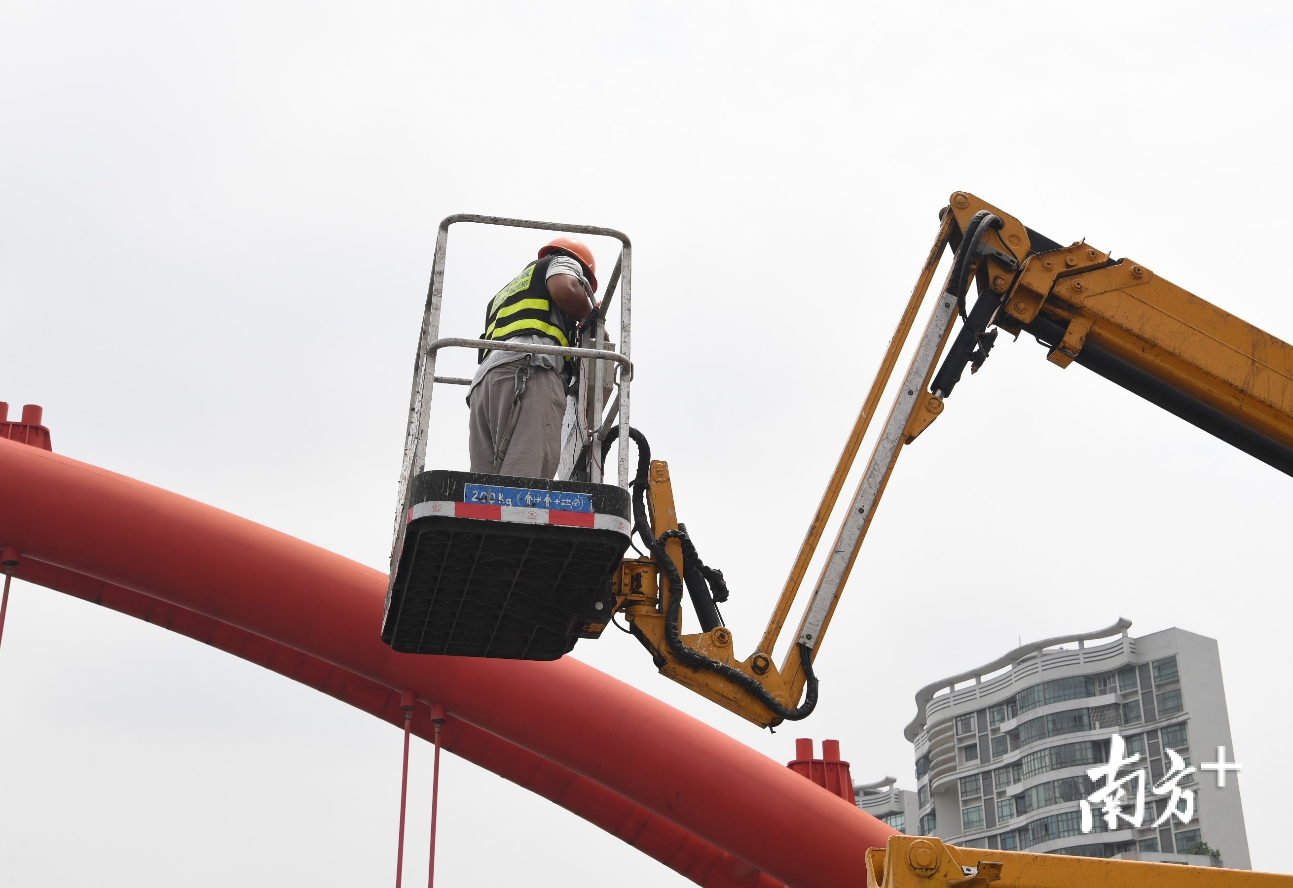 维修人员缓缓升上高空。 维修人员缓缓升上高空。