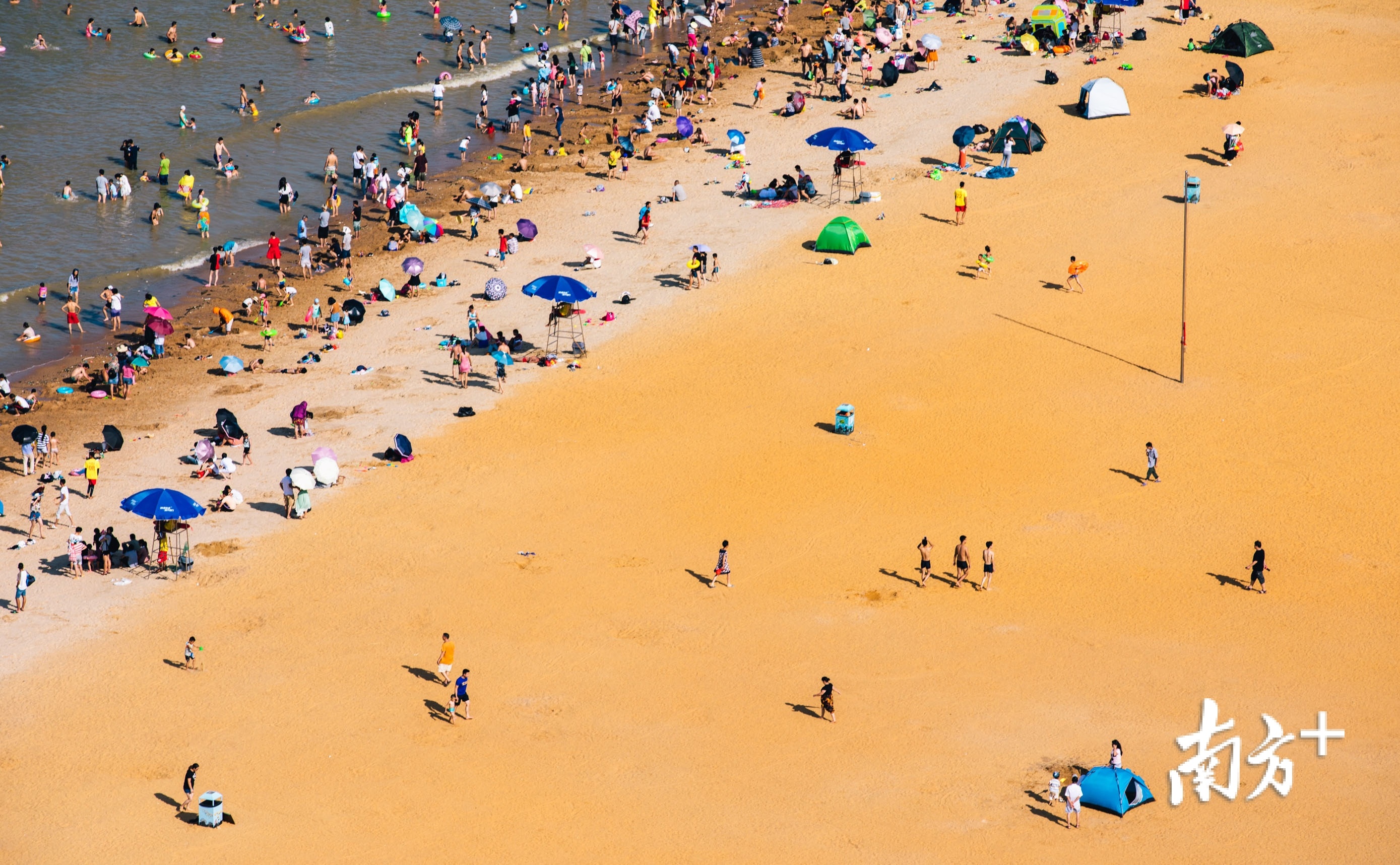 夏天的海滨泳场热闹无比,人们在浪花间嬉笑跳跃,畅享海滨之城的专属